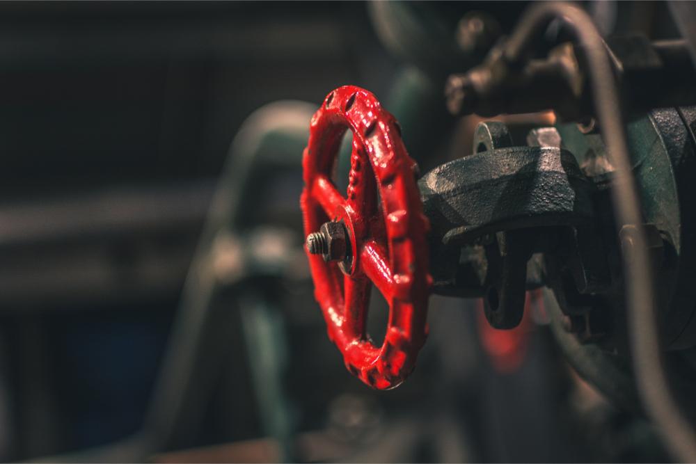 Red valve on green pipe